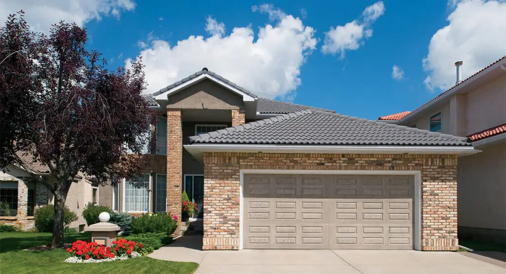 C.H.I. Model 5283 raised panel steel garage door complementing a brick home exterior.